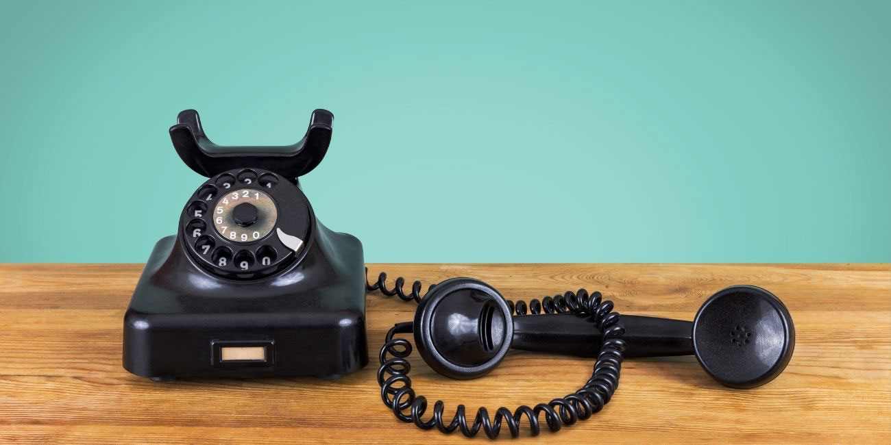 Altes Telefon mit Wählscheibe hört in der Warteschleife professionelle Telefonansagen von yuutel