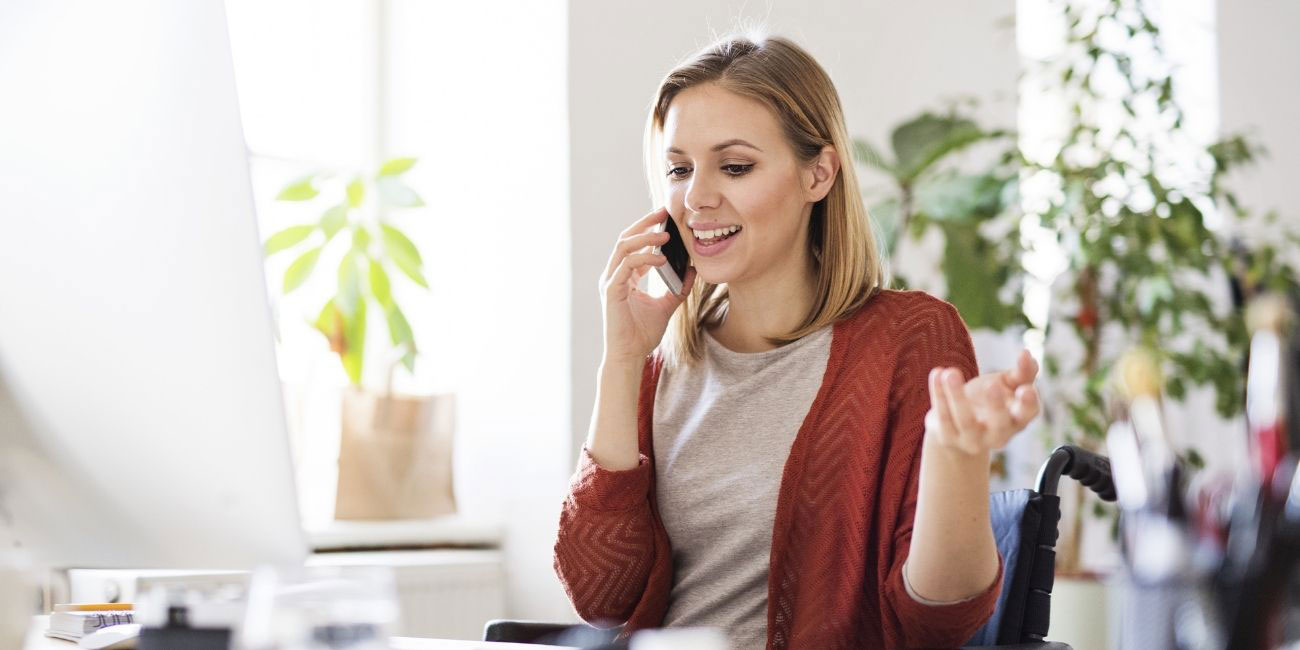 Business-Frau telefoniert zufrieden über Servicerufnummer von yuutel mit Unternehmen
